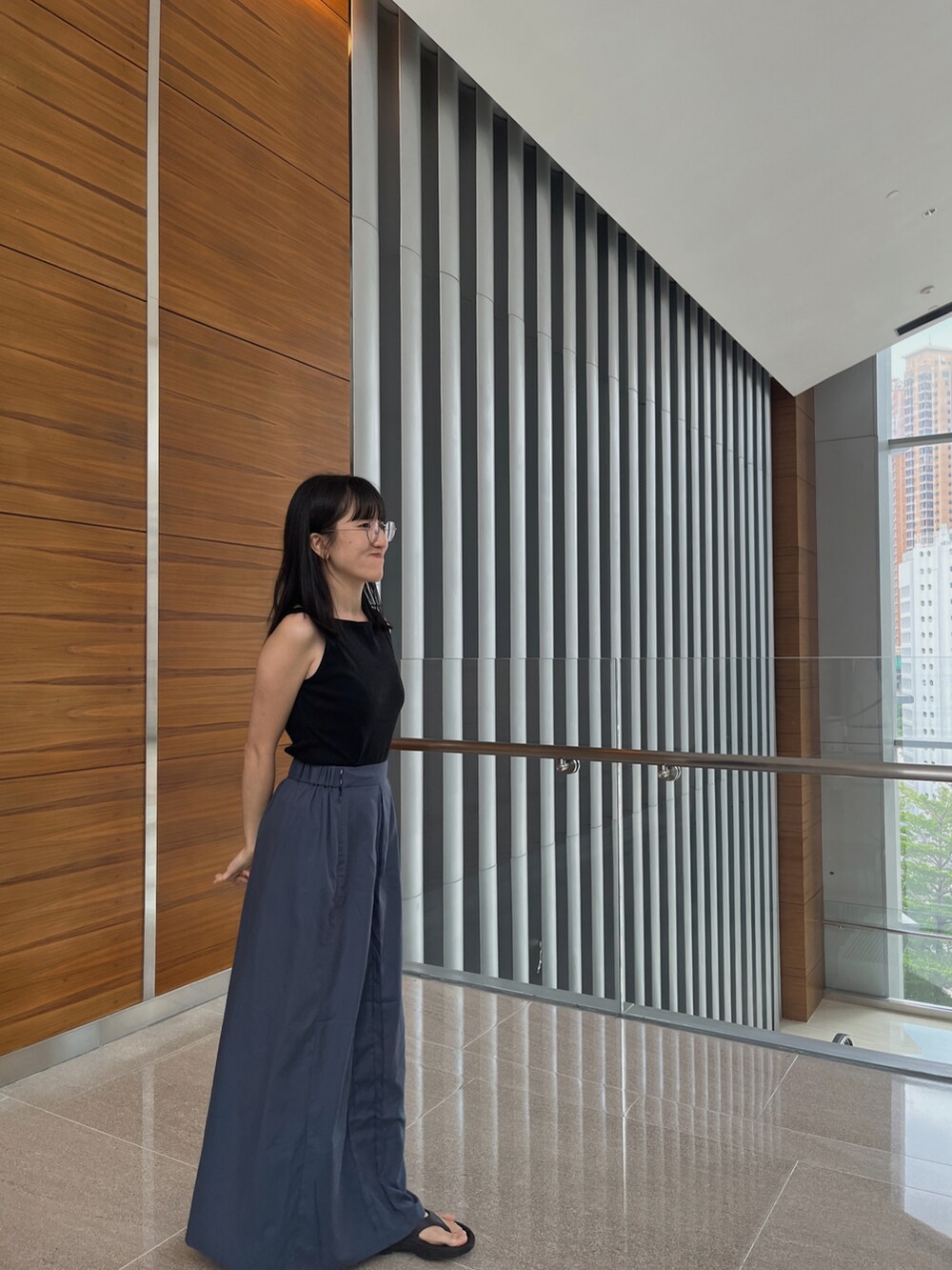 ブラック系のジャケット/アウター、ブルー系のスカート、ブラック系のサンダルを着用したレディースの夏コーディネートの2枚目の写真