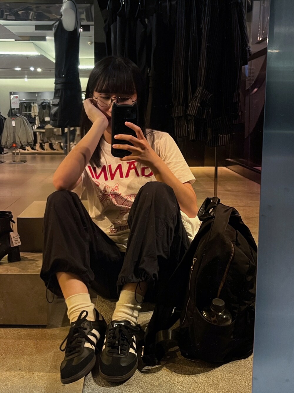 ブラック系のスニーカー、ホワイト系のTシャツ/カットソー、ブラック系のパンツを着用したレディースの秋コーディネートの2枚目の写真