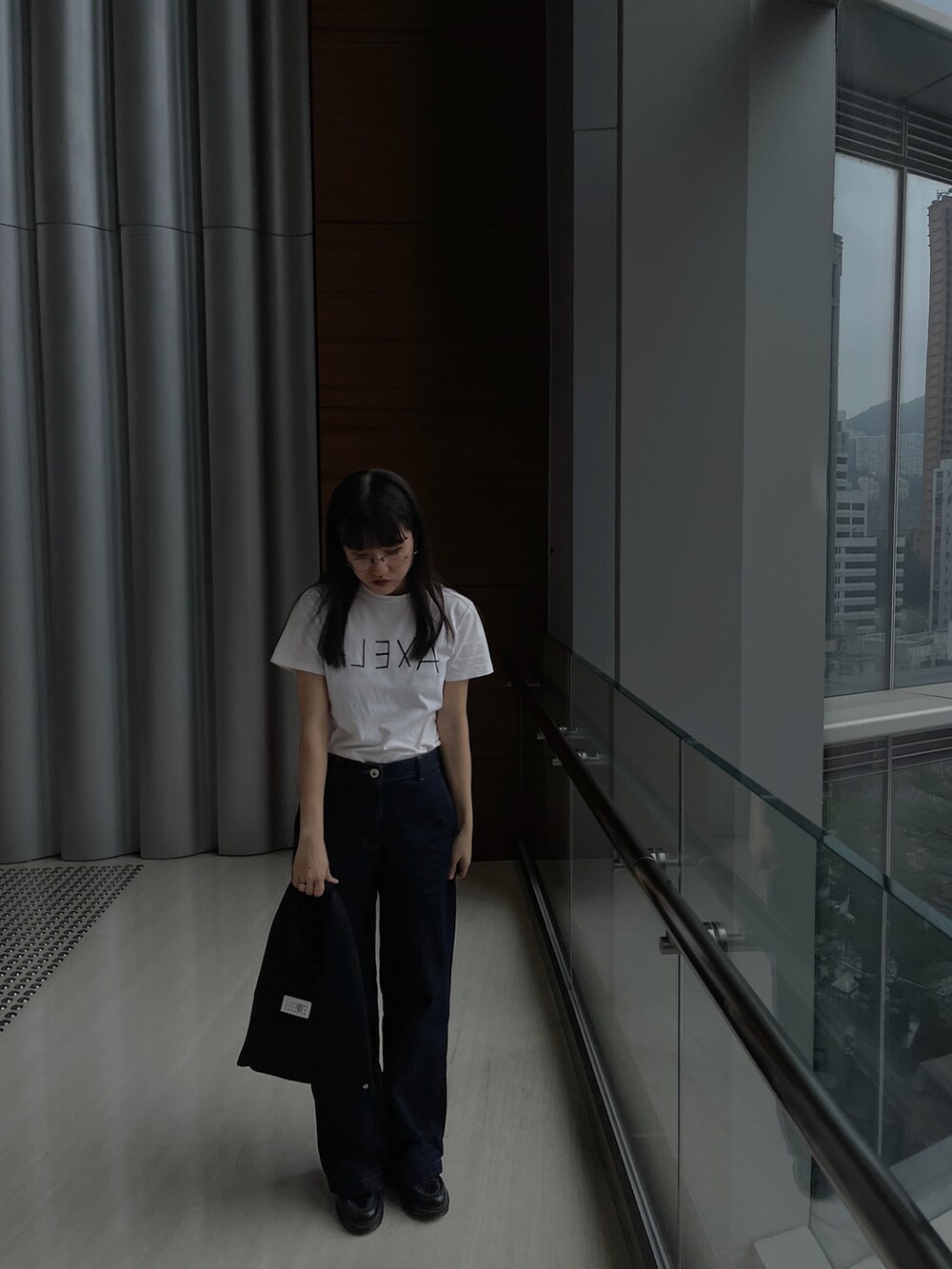 ホワイト系のTシャツ/カットソー、ブルー系のデニムパンツ、ブラック系のバッグを着用したレディースの冬コーディネートの2枚目の写真