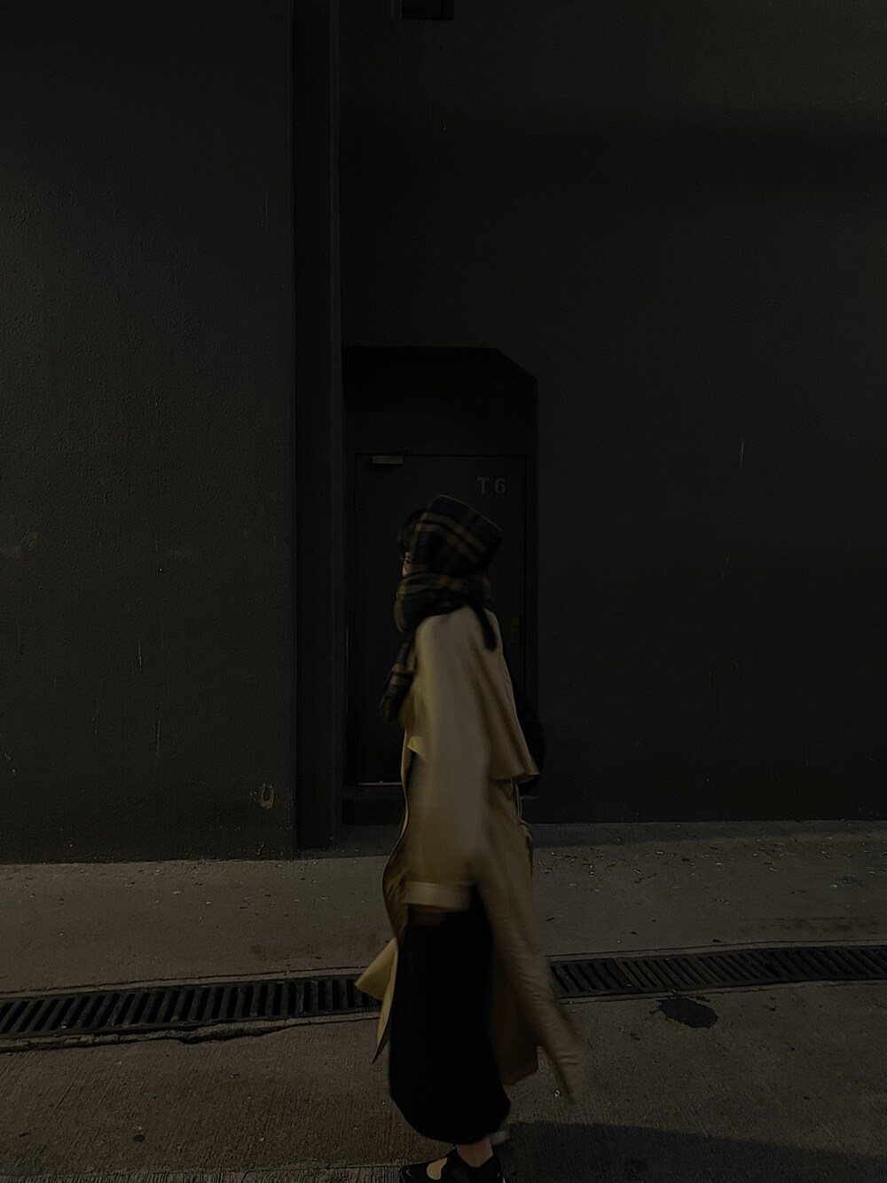 ベージュ系のトレンチコート、ブラック系のバッグ、ブラック系のスニーカーを着用したレディースの冬コーディネートの3枚目の写真