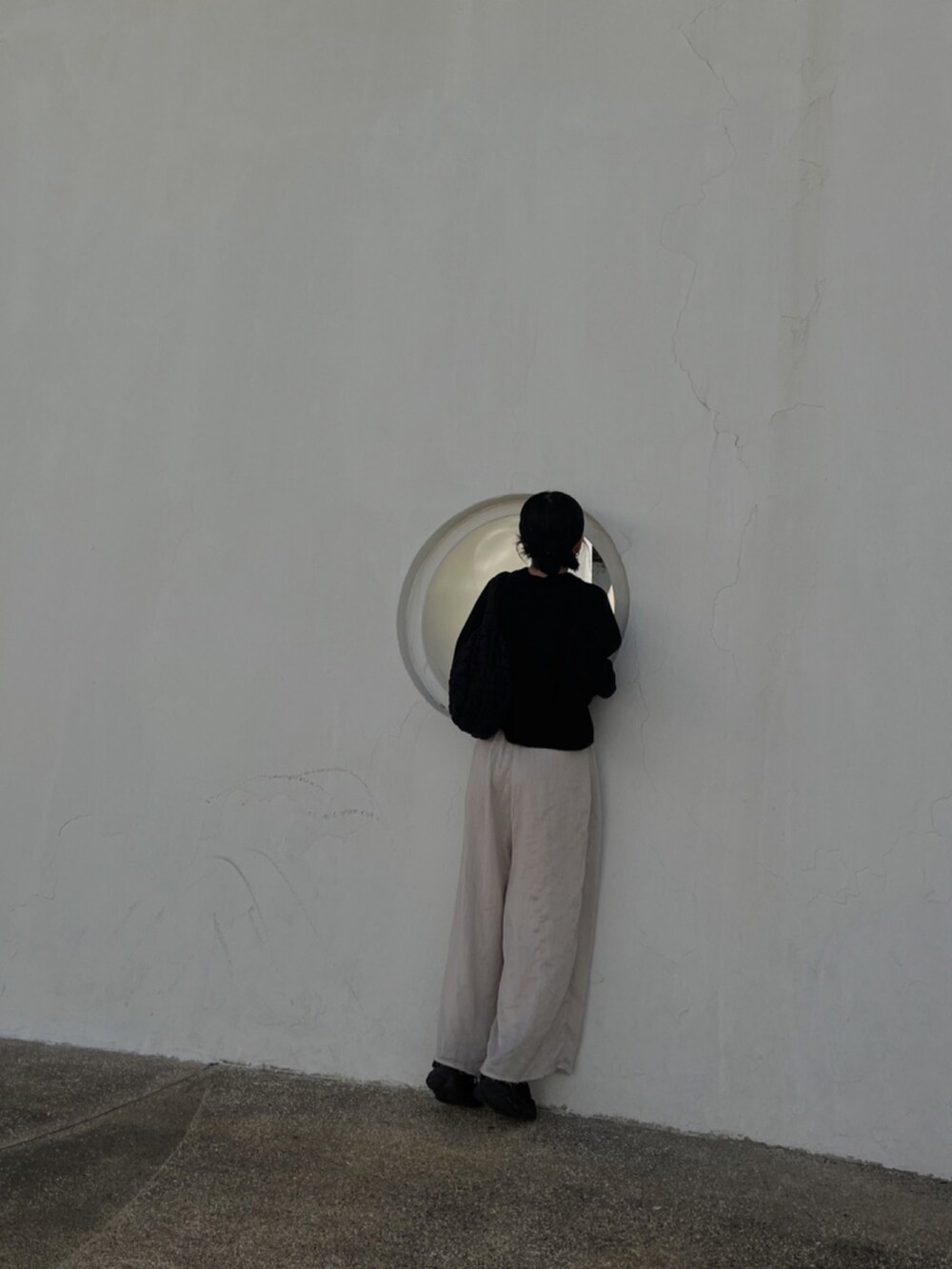 ブラック系のジャージ、ブラック系のバッグ、ブラック系のスニーカーを着用したレディースの冬コーディネートの3枚目の写真