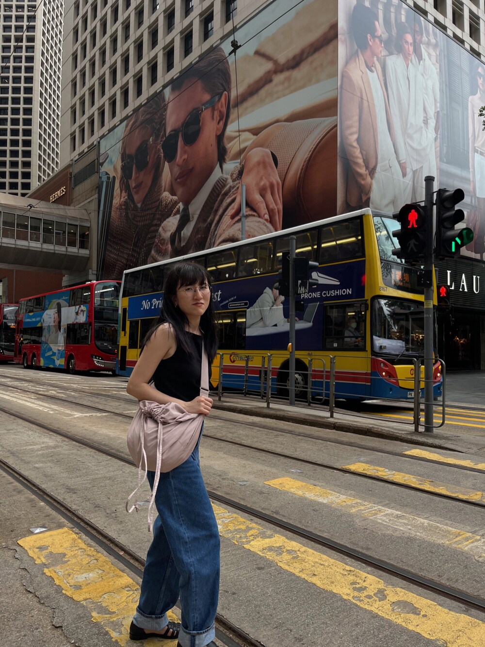 ブラック系のタンクトップ、ピンク系のバッグ、ブルー系のデニムパンツを着用したレディースの春コーディネートの2枚目の写真