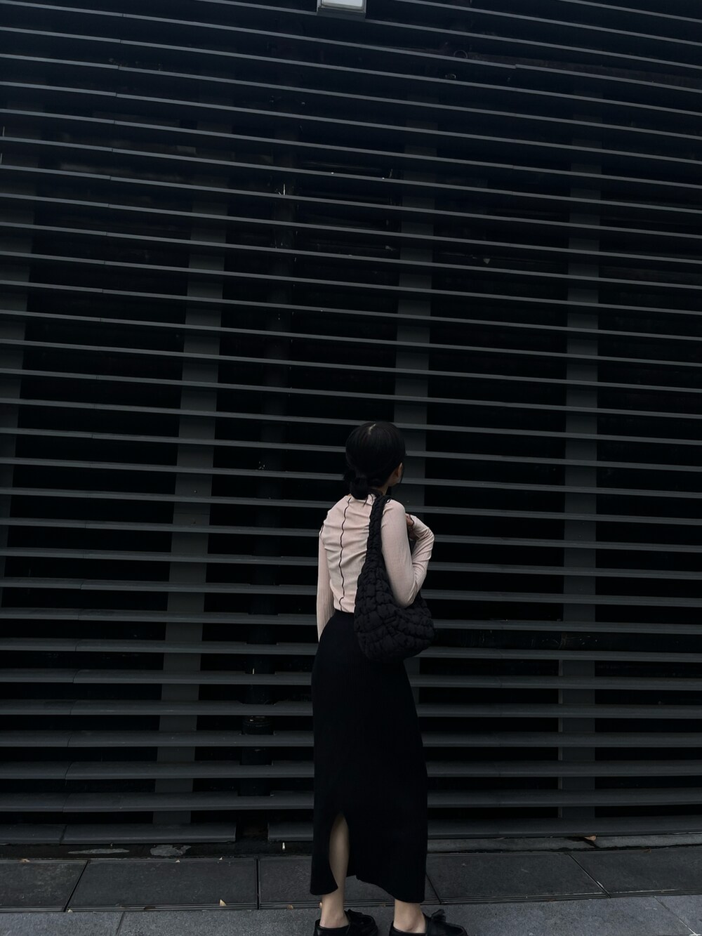 ベージュ系のTシャツ/カットソー、ブラック系のスカート、ブラック系のローファーを着用したレディースの冬コーディネートの2枚目の写真