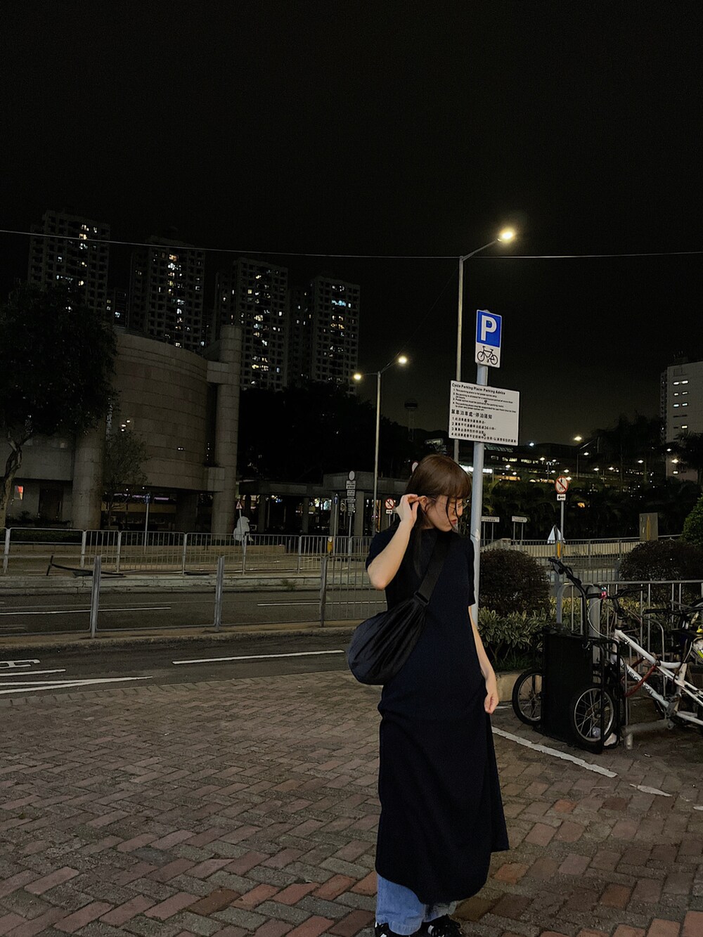 ブラック系のカーディガン/ボレロ、ブラック系のバッグ、ブルー系のワンピースを着用したレディースの冬コーディネートの2枚目の写真