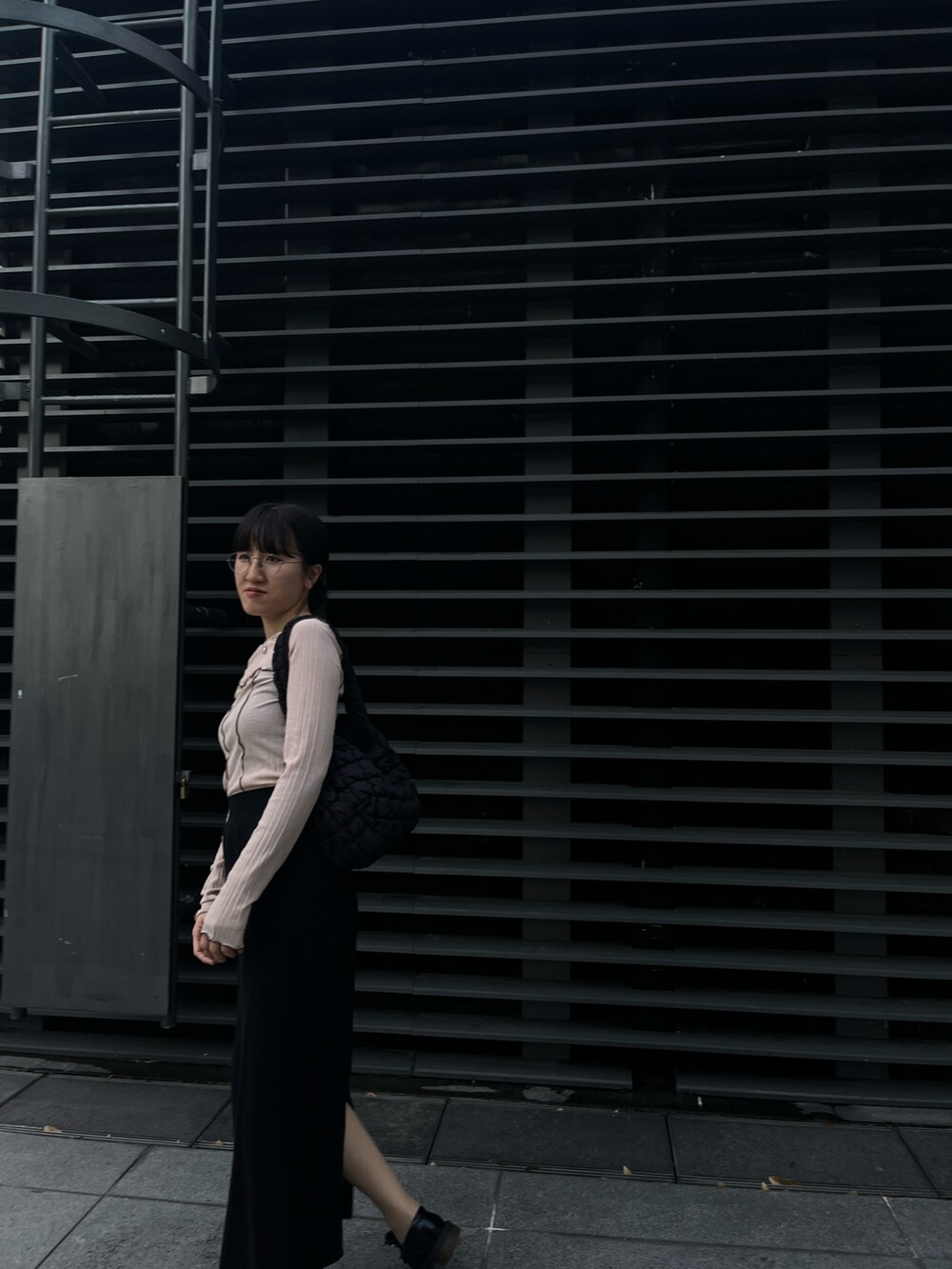 ベージュ系のTシャツ/カットソー、ブラック系のスカート、ブラック系のローファーを着用したレディースの冬コーディネートの3枚目の写真