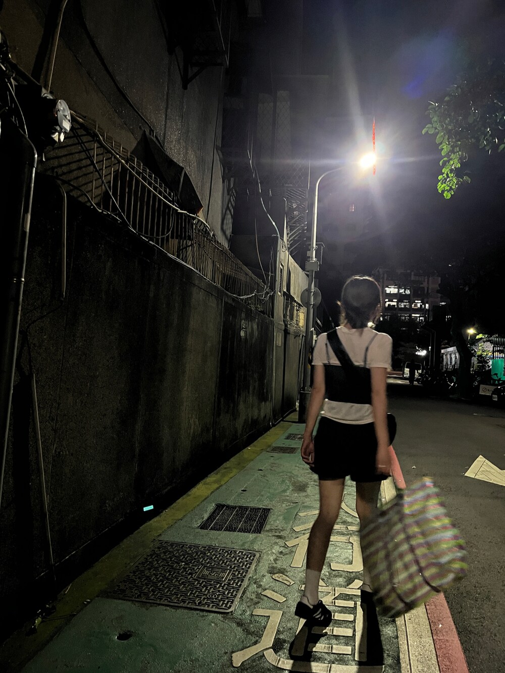 グレー系のトップス、ブラック系のショルダーバッグ、ホワイト系のTシャツ/カットソーを着用したレディースの春コーディネートの2枚目の写真