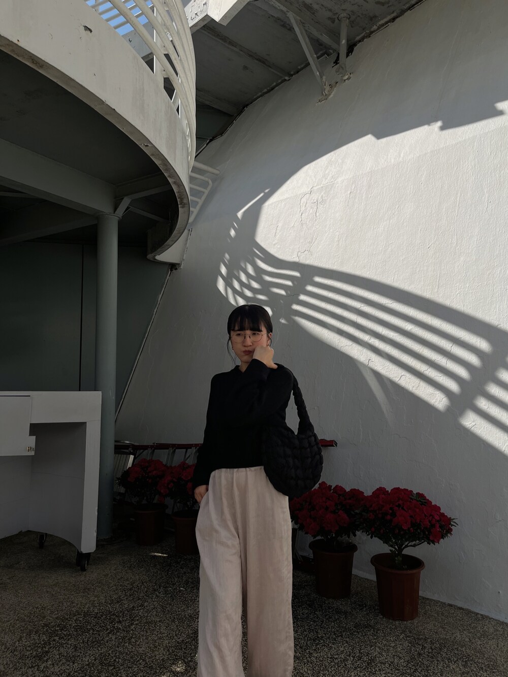 ブラック系のジャージ、ブラック系のバッグ、ブラック系のスニーカーを着用したレディースの冬コーディネートの4枚目の写真