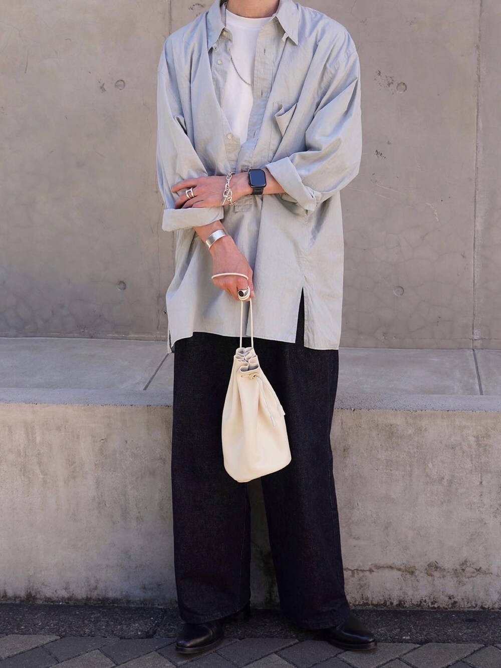 ホワイト系のショルダーバッグ、ブラック系のシューズ、ブルー系のデニムパンツを着用したメンズの秋コーディネートの3枚目の写真