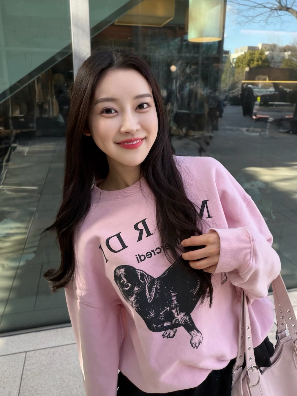 ブラック系のブーツ、ブラック系のスカート、ピンク系のスウェットを着用したレディースの春コーディネートの3枚目の写真