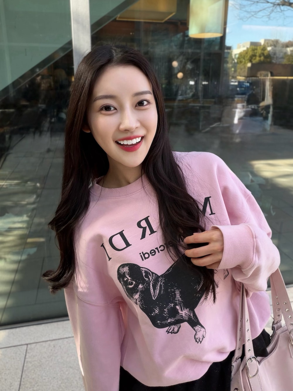 ブラック系のブーツ、ブラック系のスカート、ピンク系のスウェットを着用したレディースの春コーディネートの4枚目の写真