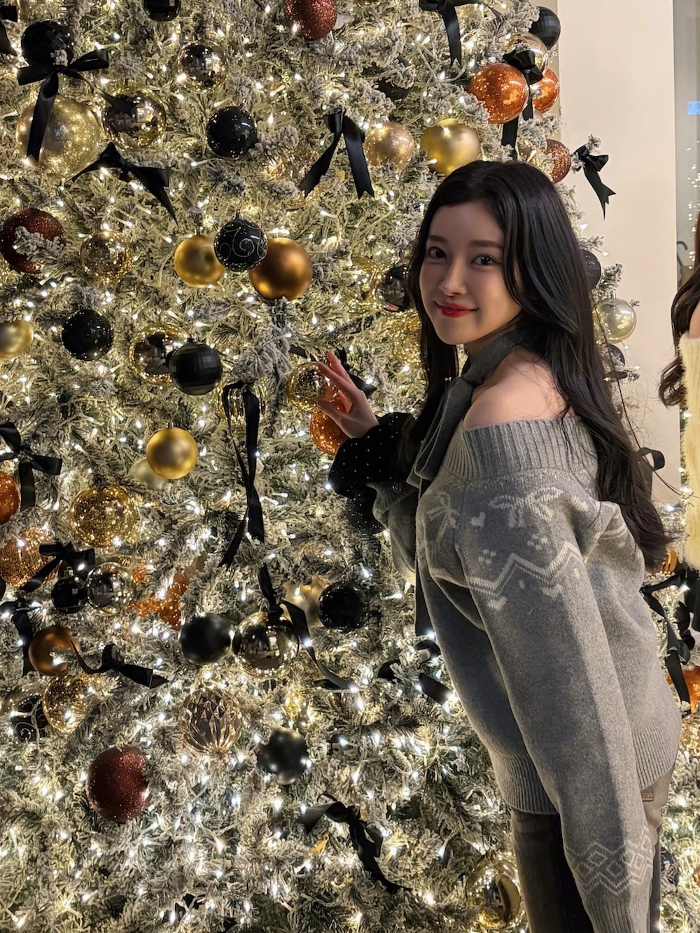 グレー系のニット/セーター、ブラック系のシュシュを着用したレディースの冬コーディネートの2枚目の写真