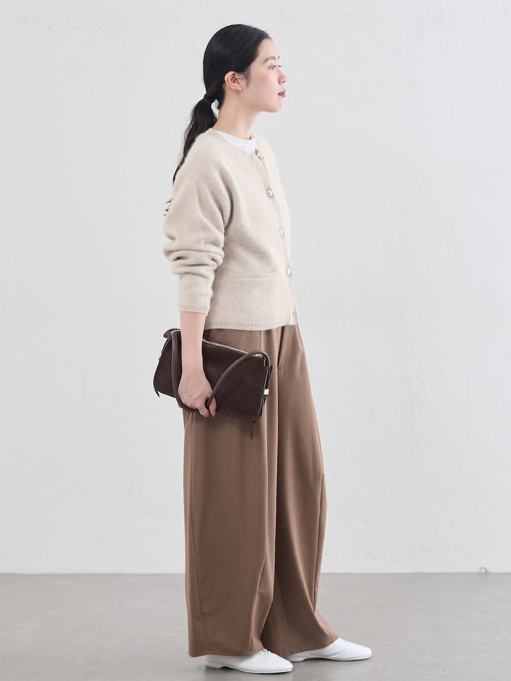 ブラウン系のその他パンツ、ホワイト系のカーディガン/ボレロ、ブラウン系のショルダーバッグを着用したレディースの秋コーディネートの2枚目の写真