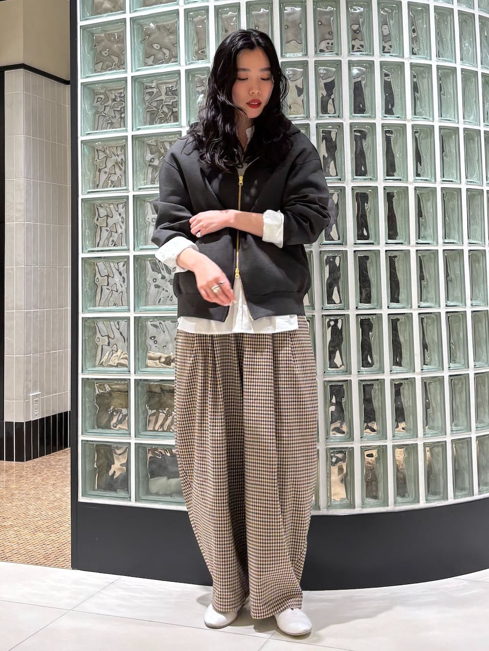 ベージュ系のステンカラーコート、ベージュ系のその他パンツ、ホワイト系のシャツ/ブラウスを着用したレディースの冬コーディネートの2枚目の写真