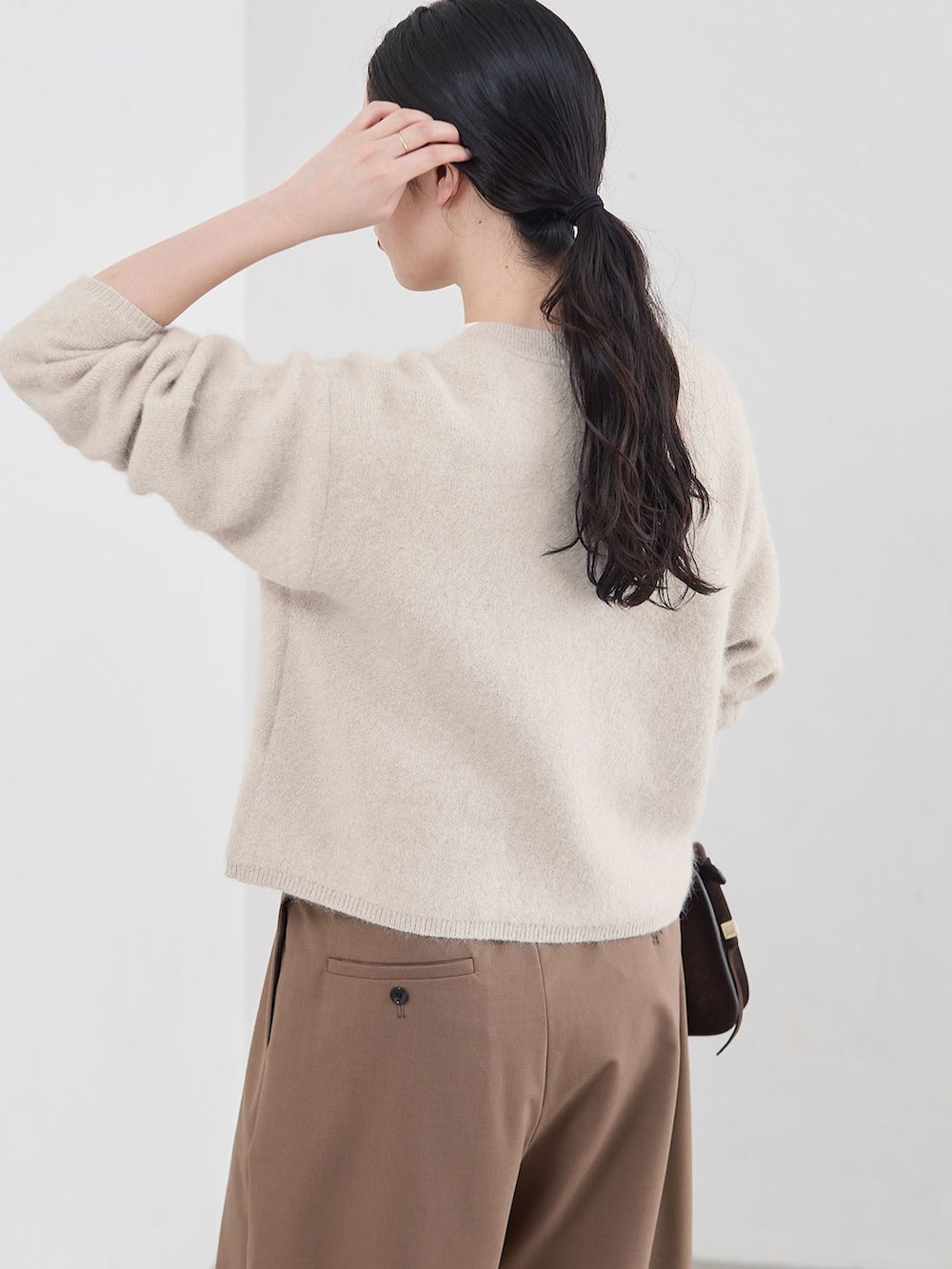 ブラウン系のその他パンツ、ホワイト系のカーディガン/ボレロ、ブラウン系のショルダーバッグを着用したレディースの秋コーディネートの5枚目の写真