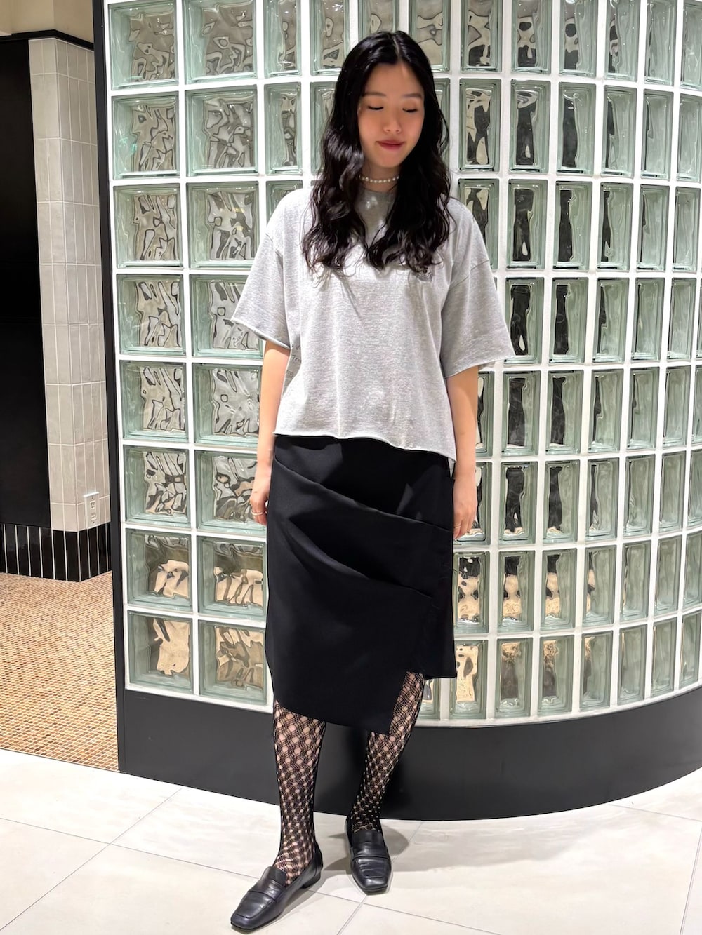 グレー系のTシャツ/カットソー、ブラック系のタイツ/ストッキングを着用したレディースの夏コーディネートの2枚目の写真