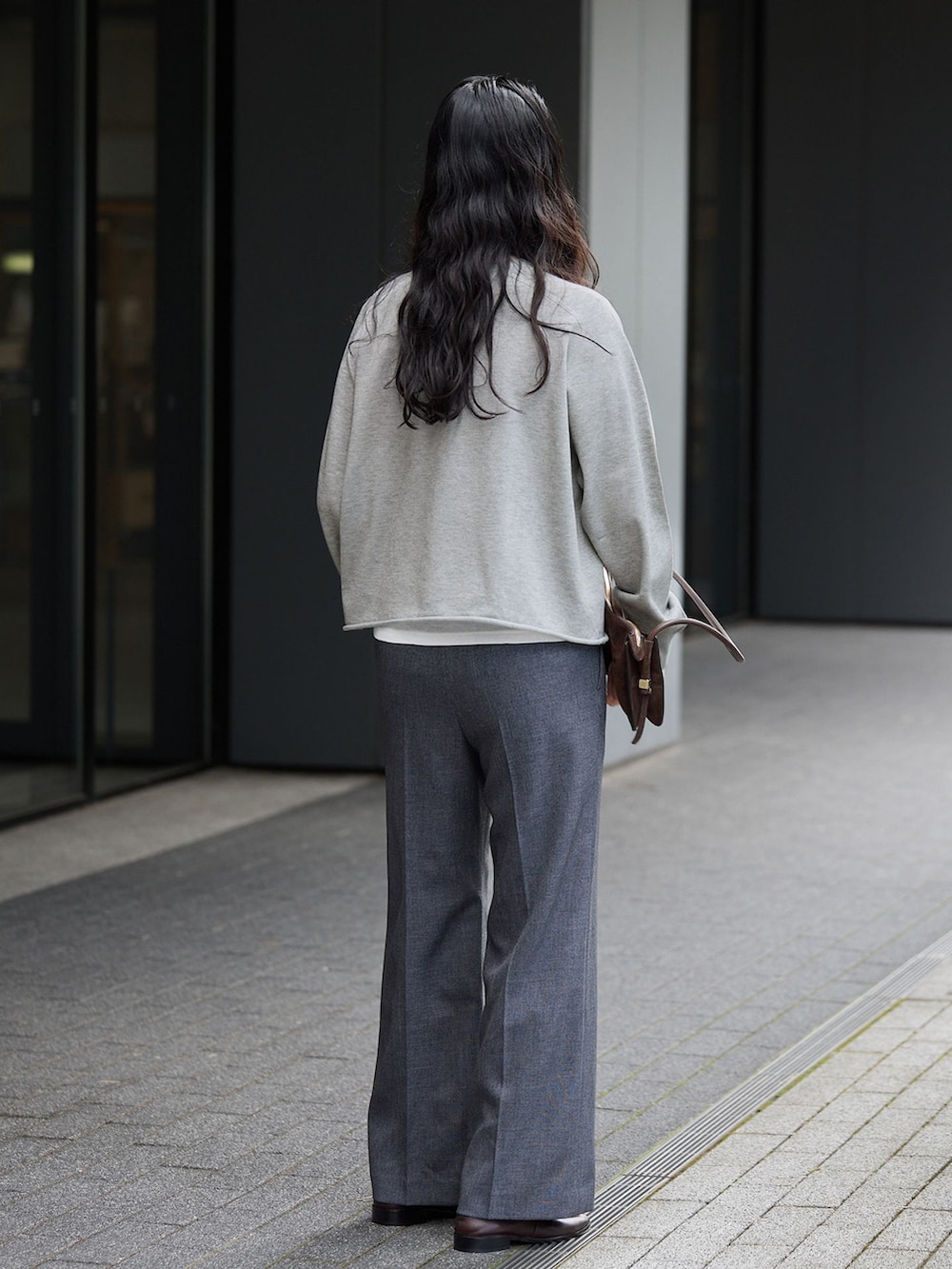 ブラック系のその他パンツ、グレー系のニット/セーター、ブラウン系のローファーを着用したレディースの秋コーディネートの3枚目の写真