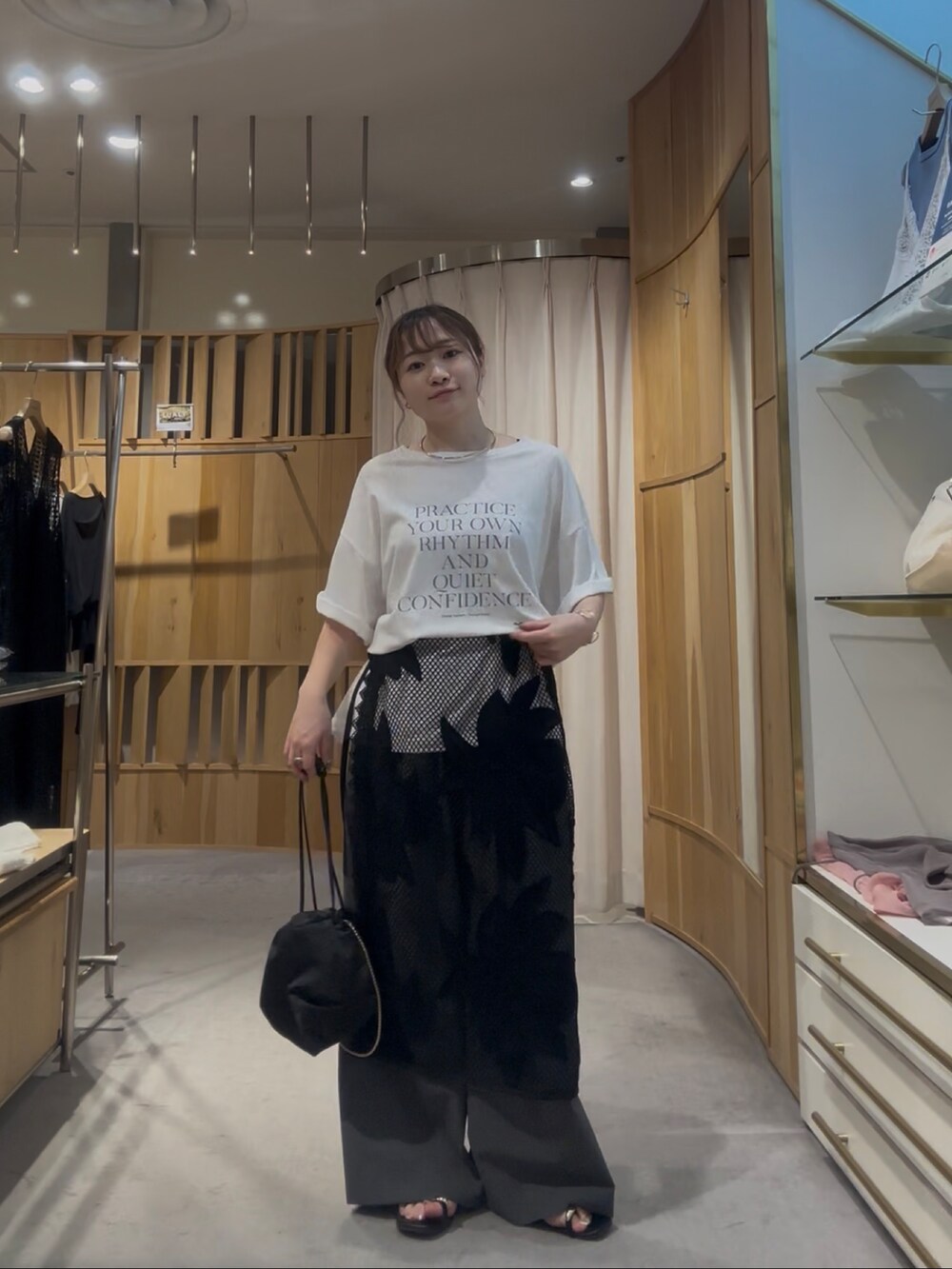 ホワイト系のTシャツ/カットソー、ブラック系のスカートを着用したレディースの夏コーディネートの2枚目の写真