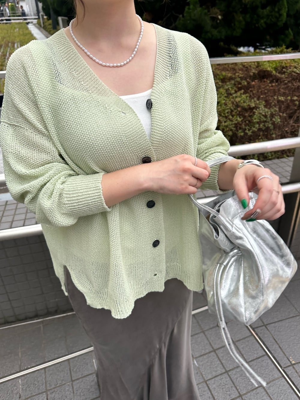 ブラウン系のスカート、シルバー系のトートバッグ、ホワイト系のニット/セーターを着用したレディースの夏コーディネートの3枚目の写真