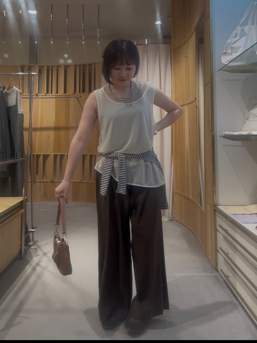 ホワイト系のタンクトップ、ブラウン系のその他パンツを着用したレディースの夏コーディネートの2枚目の写真