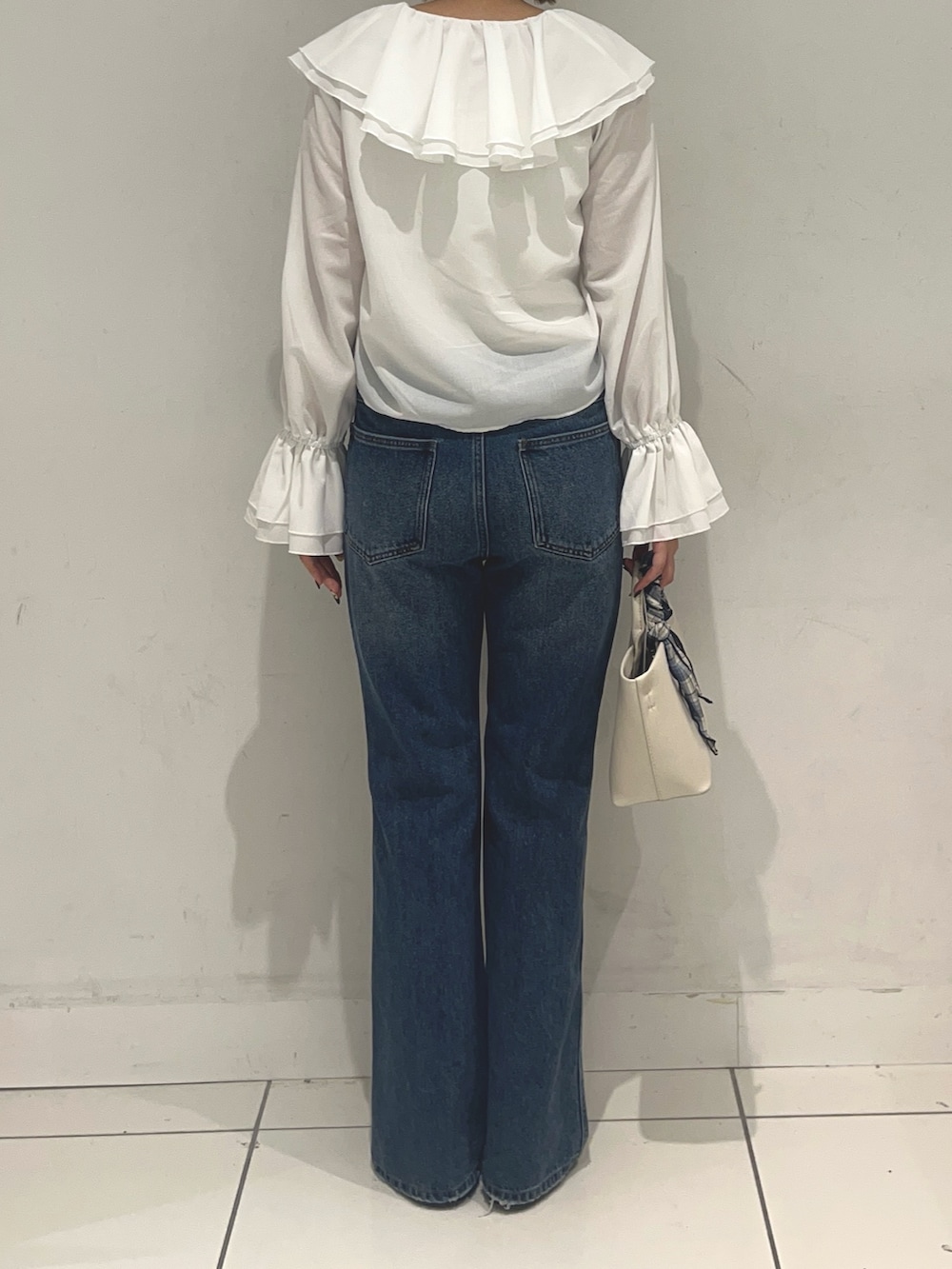 ホワイト系のシャツ/ブラウス、ブルー系のデニムパンツ、ホワイト系のトートバッグを着用したレディースの春コーディネートの2枚目の写真