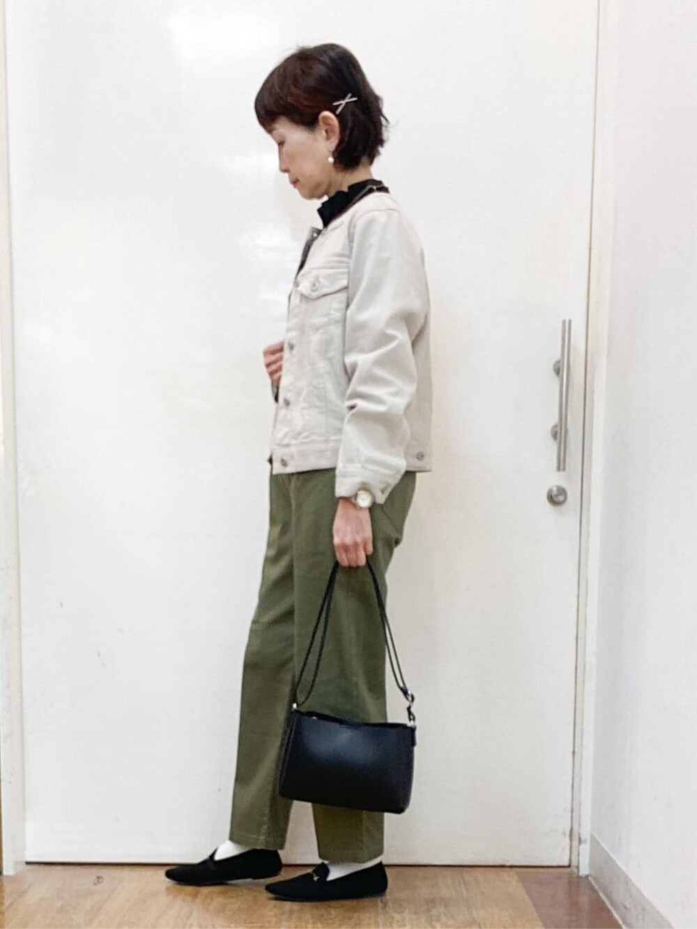 グレー系のデニムジャケット、ブラック系のシャツ/ブラウス、グリーン系のその他パンツを着用したレディースの春コーディネートの2枚目の写真