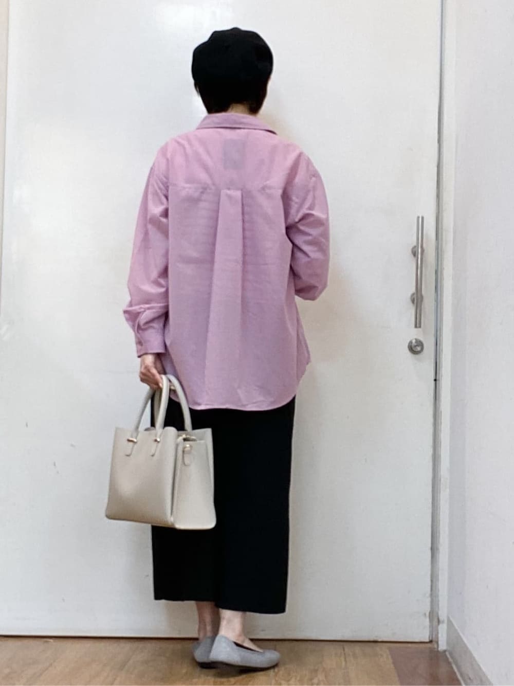 ピンク系のシャツ/ブラウス、ブラック系のニット/セーター、ブラック系のスカートを着用したレディースの春コーディネートの3枚目の写真