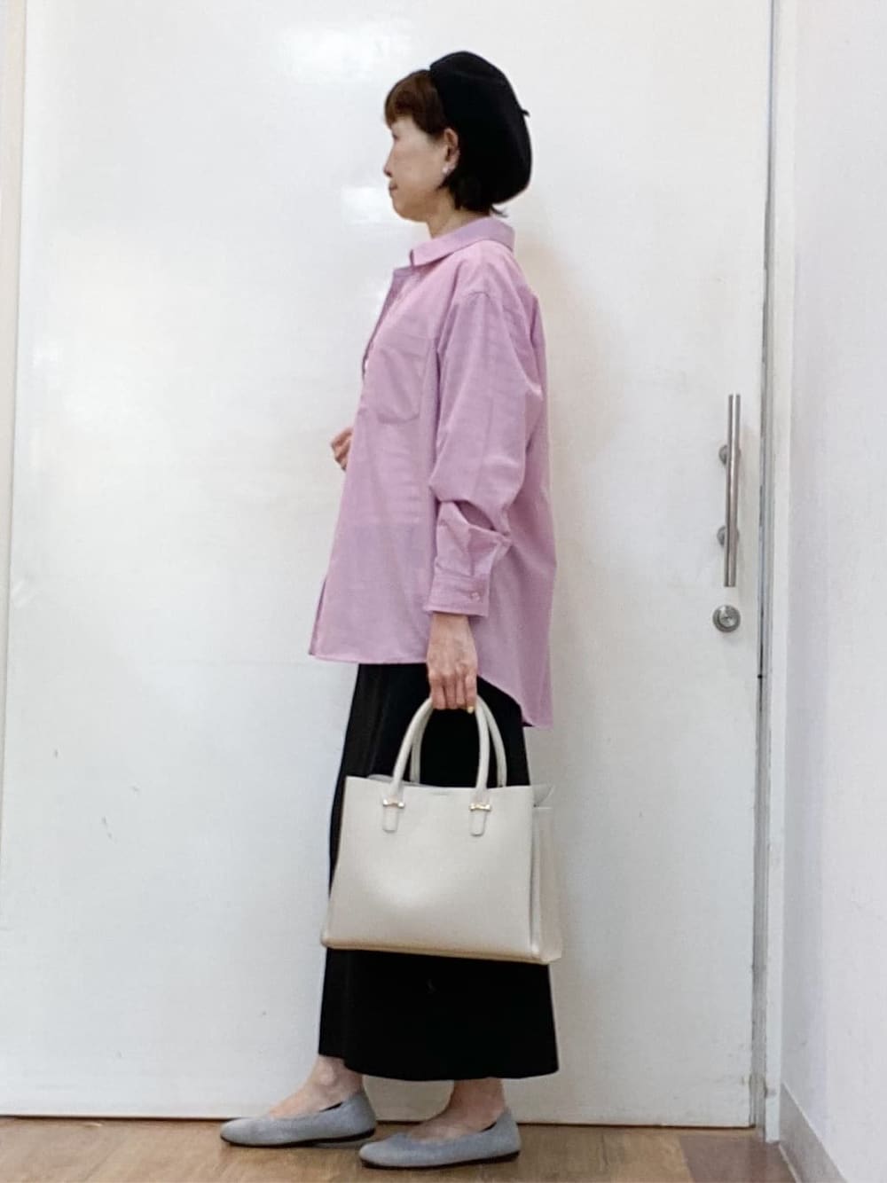 ピンク系のシャツ/ブラウス、ブラック系のニット/セーター、ブラック系のスカートを着用したレディースの春コーディネートの2枚目の写真