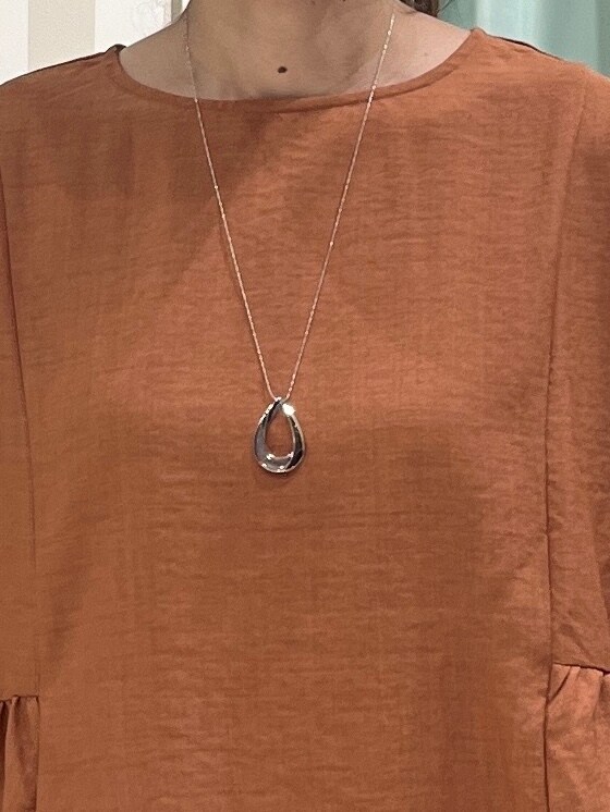 レッド系のシャツ/ブラウス、ブラック系のその他パンツ、ブラック系のパンプスを着用したレディースの秋コーディネートの6枚目の写真