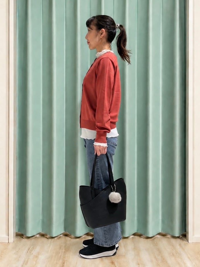 レッド系のカーディガン/ボレロ、ホワイト系のTシャツ/カットソー、ブルー系のデニムパンツを着用したレディースの秋コーディネートの2枚目の写真
