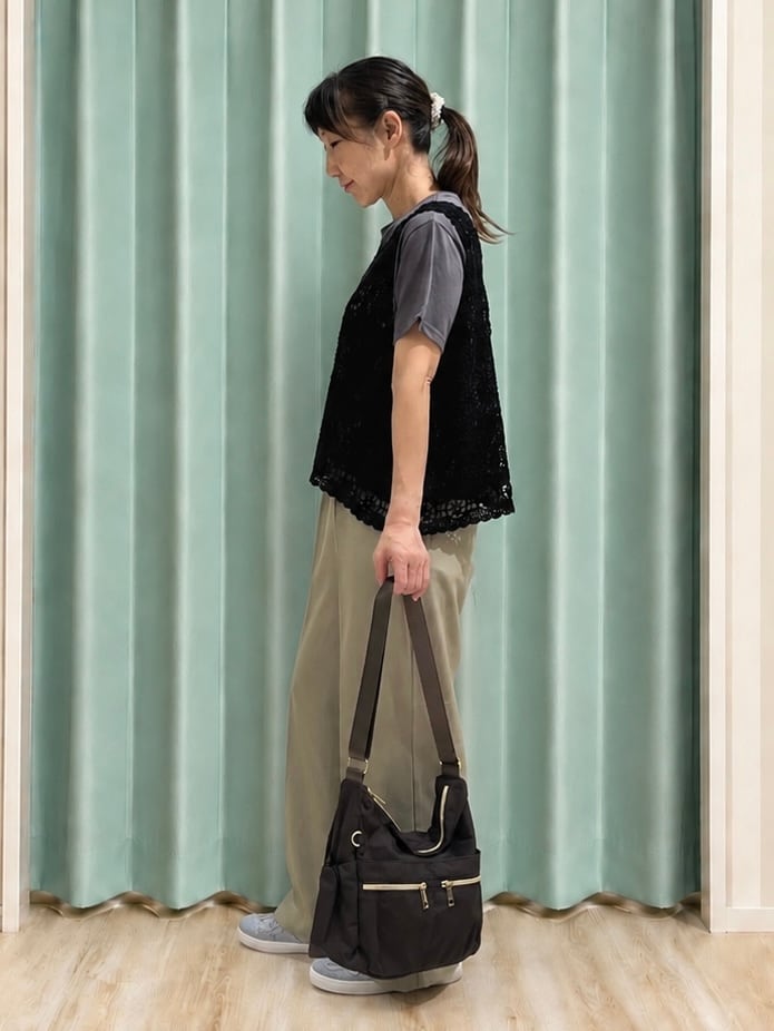 グリーン系のその他パンツ、シルバー系のその他シューズ、ブラウン系のショルダーバッグを着用したレディースの秋コーディネートの2枚目の写真