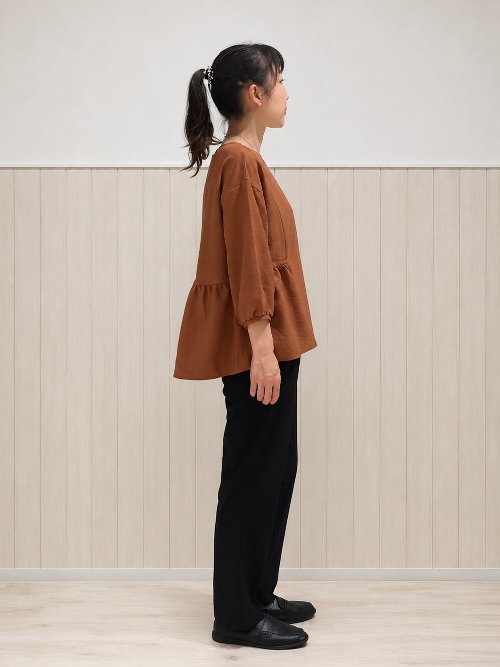レッド系のシャツ/ブラウス、ブラック系のその他パンツ、ブラック系のパンプスを着用したレディースの秋コーディネートの2枚目の写真