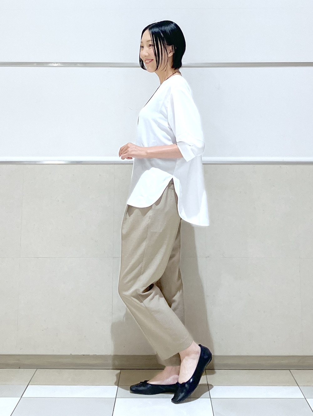ホワイト系のシャツ/ブラウス、ベージュ系のその他パンツ、ブラック系のパンプスを着用したレディースの夏コーディネートの7枚目の写真