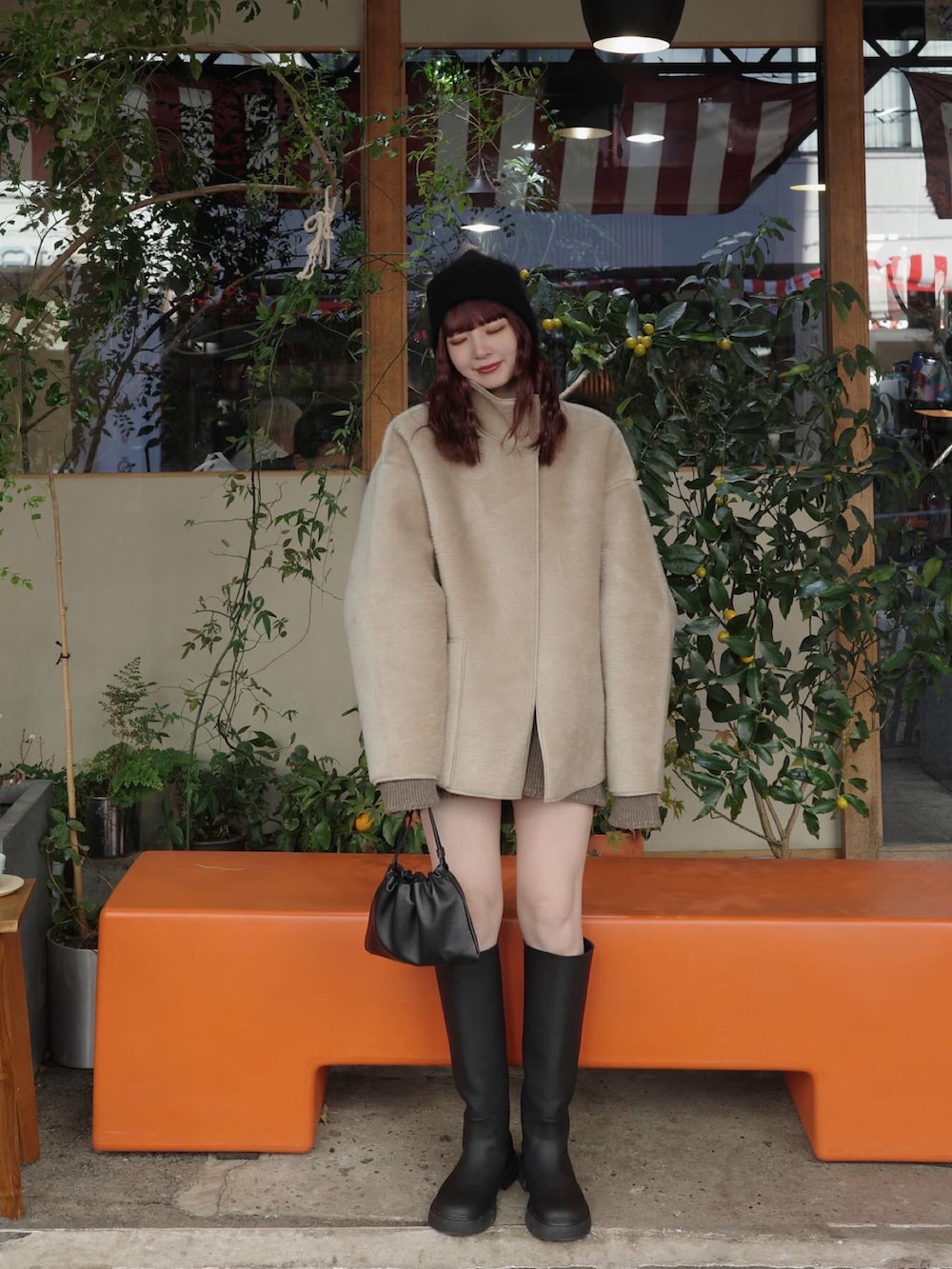 ベージュ系のジャケット/アウター、ブラック系のブーツ、ブラック系のバッグを着用したレディースの冬コーディネートの2枚目の写真