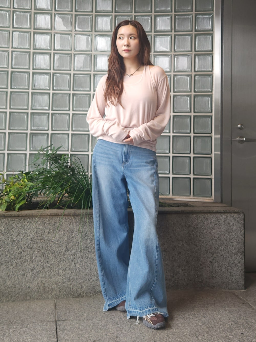ブラウン系のブルゾン、ベージュ系のTシャツ/カットソー、ブルー系のデニムパンツを着用したレディースの秋コーディネートの2枚目の写真