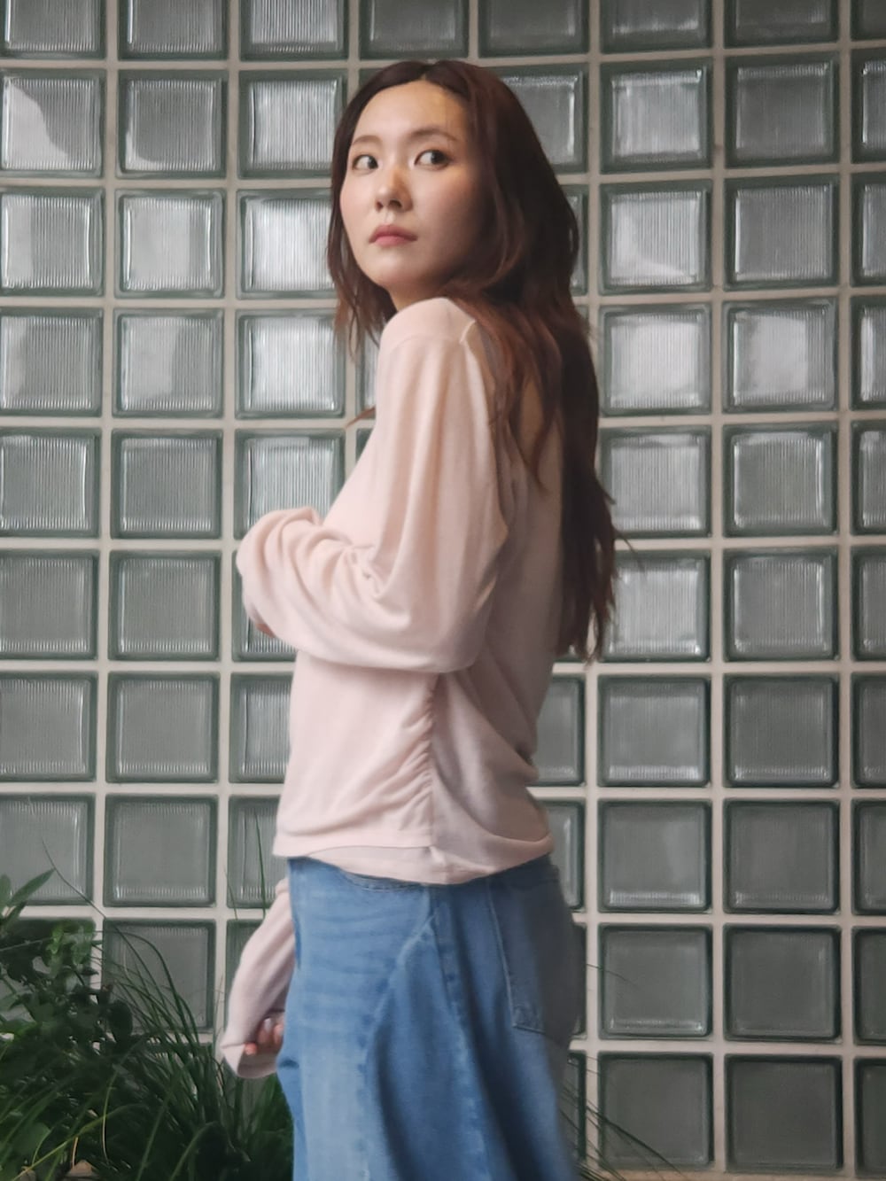 ブラウン系のブルゾン、ベージュ系のTシャツ/カットソー、ブルー系のデニムパンツを着用したレディースの秋コーディネートの3枚目の写真