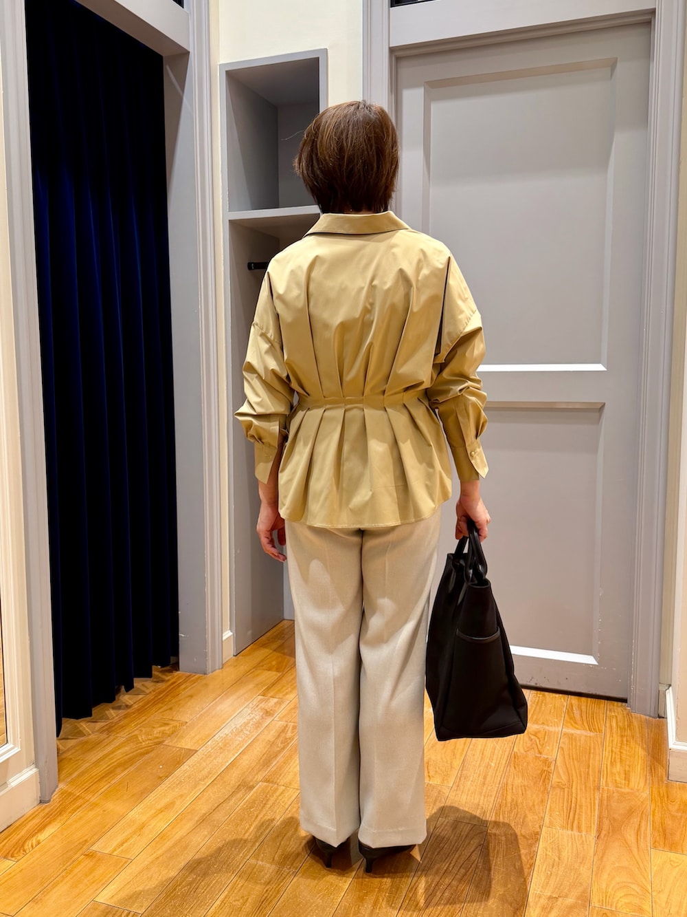 イエロー系のシャツ/ブラウス、ベージュ系のその他パンツ、ブラック系のパンプスを着用したレディースの秋コーディネートの5枚目の写真
