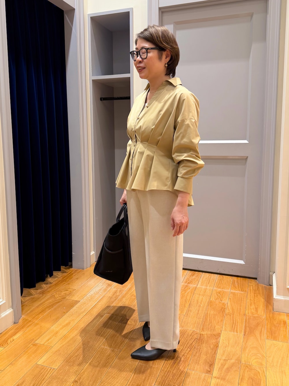 イエロー系のシャツ/ブラウス、ベージュ系のその他パンツ、ブラック系のパンプスを着用したレディースの秋コーディネートの3枚目の写真