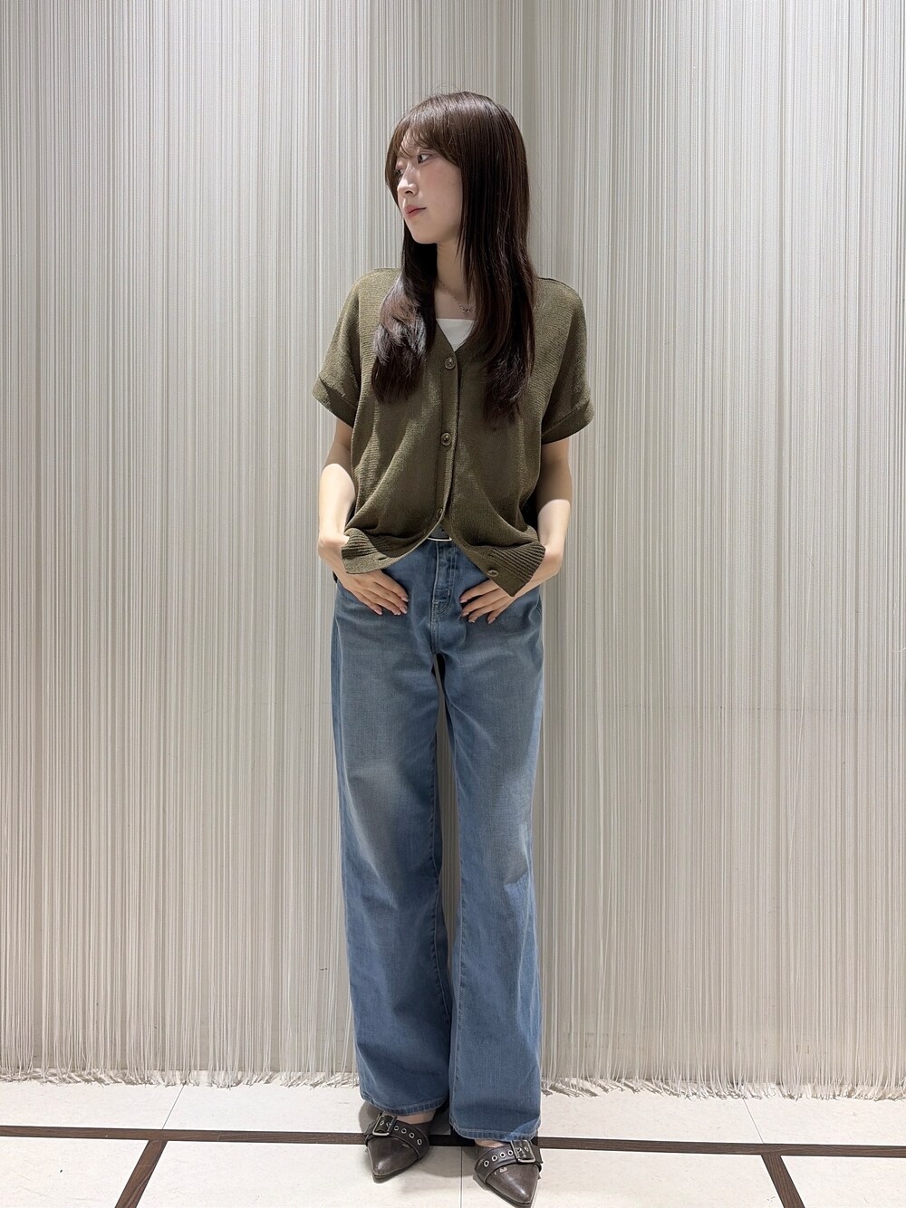 グリーン系のカーディガン/ボレロ、ブルー系のデニムパンツ、ホワイト系のタンクトップを着用したレディースの夏コーディネートの3枚目の写真