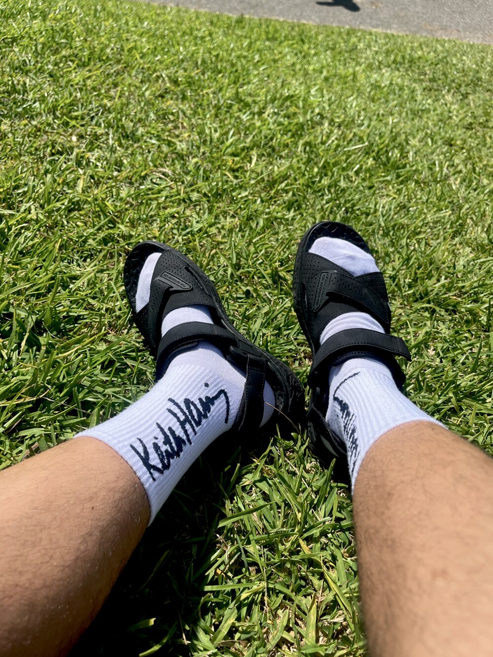 ブラック系のサンダル、ブラック系のその他パンツ、ホワイト系のTシャツ/カットソーを着用したメンズの秋コーディネートの2枚目の写真