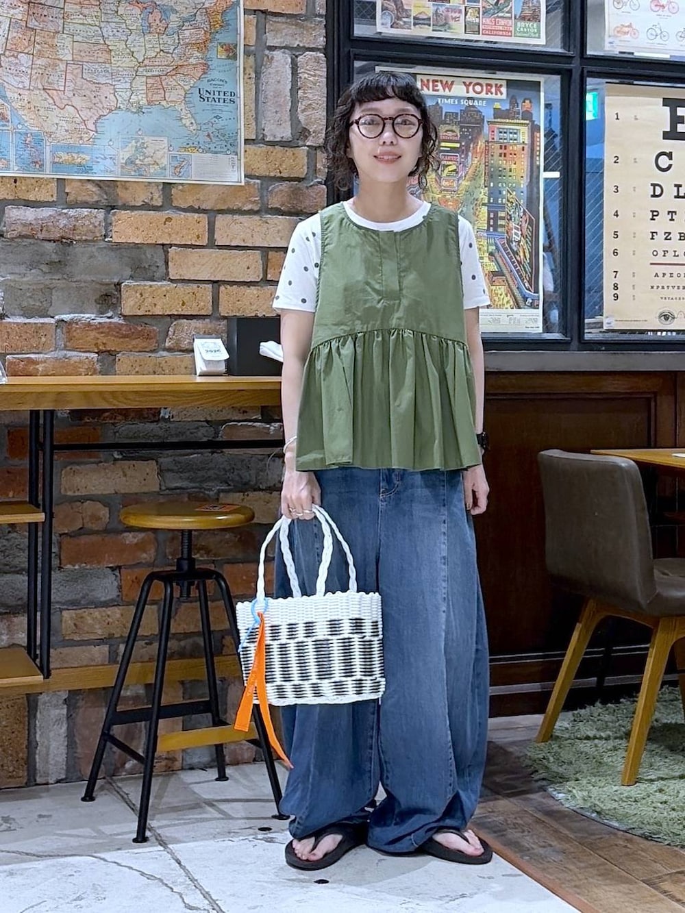 ブルー系のデニムパンツ、グリーン系のベスト、その他のかごバッグを着用したレディースの夏コーディネートの5枚目の写真