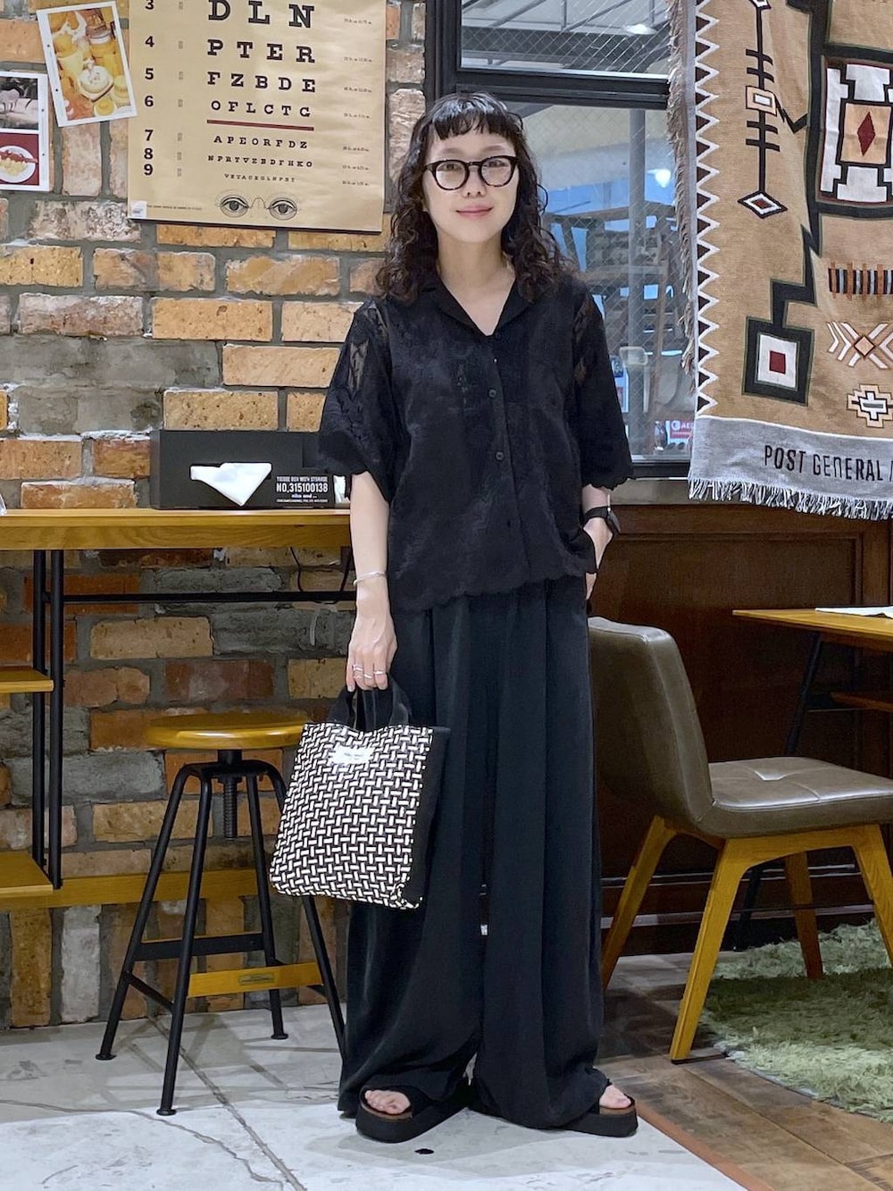 ブラック系のその他パンツ、ブラック系のサンダル、ブラック系のトートバッグを着用したレディースの夏コーディネートの5枚目の写真