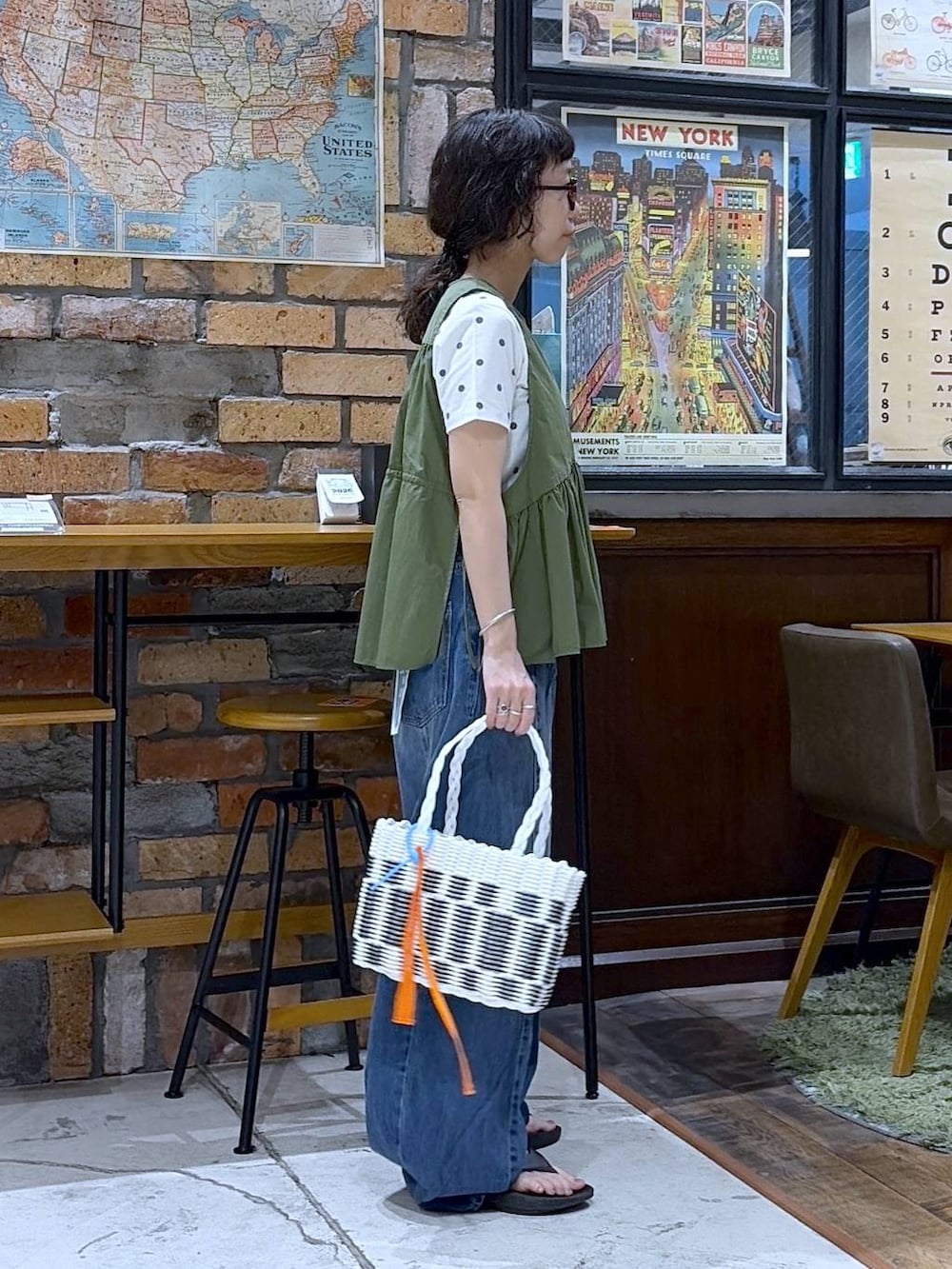 ブルー系のデニムパンツ、グリーン系のベスト、その他のかごバッグを着用したレディースの夏コーディネートの4枚目の写真