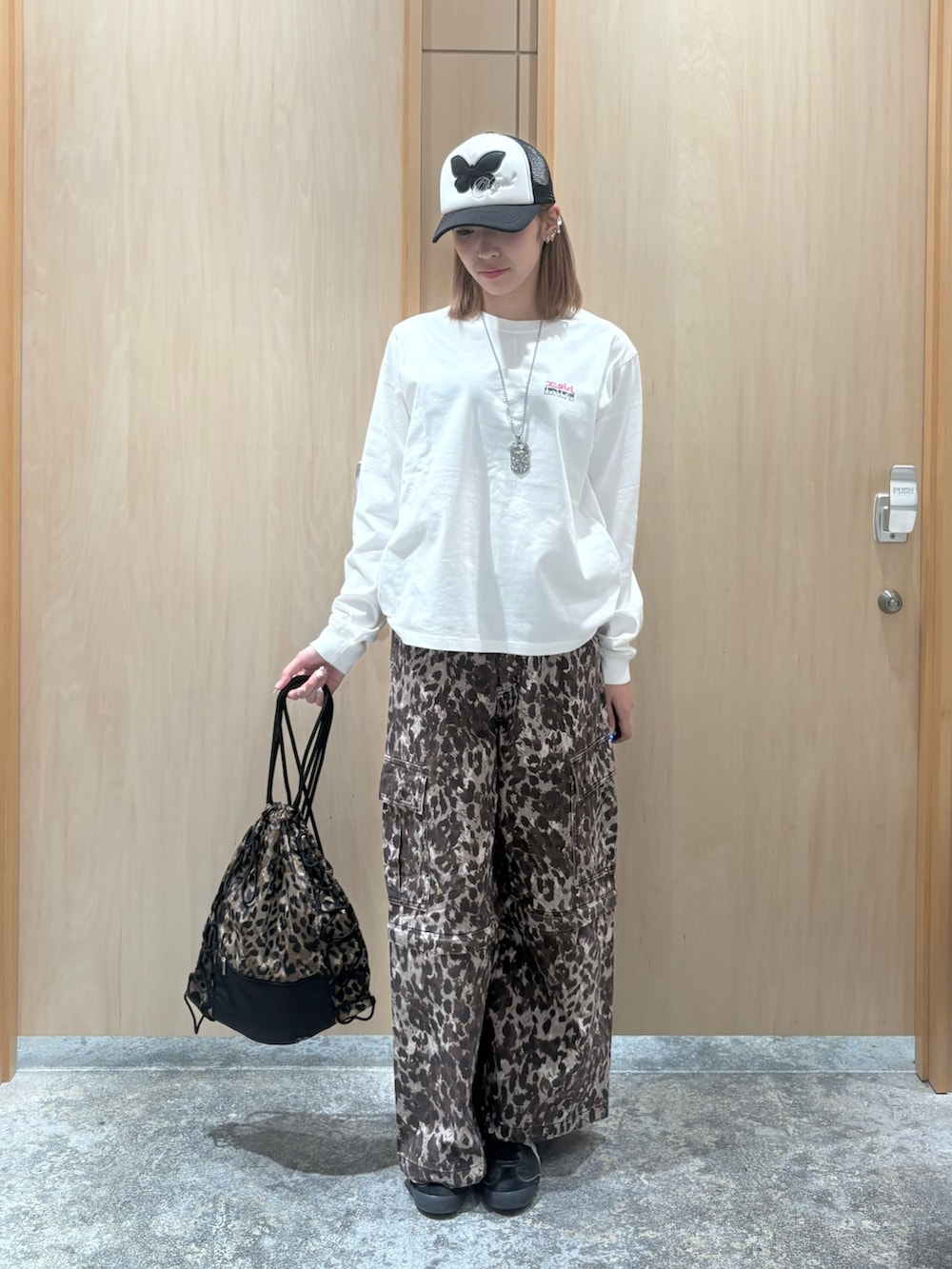 ホワイト系のTシャツ/カットソー、ベージュ系のカーゴパンツ、ベージュ系のバックパック/リュックを着用したレディースの夏コーディネートの3枚目の写真