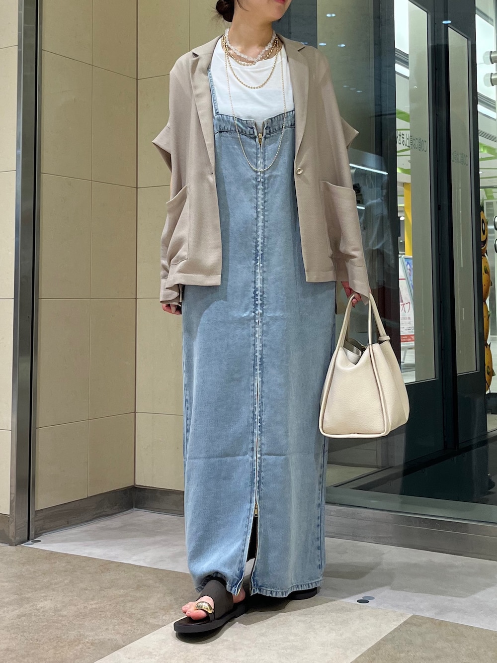 ブルー系のワンピース、ホワイト系のハンドバッグ、ブラック系のサンダルを着用したレディースの夏コーディネートの5枚目の写真