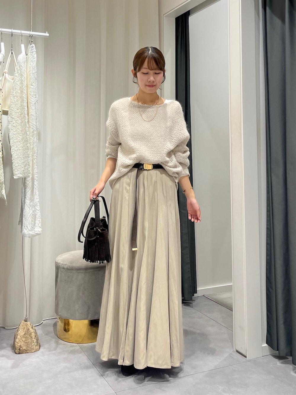 ベージュ系のスカート、ベージュ系のニット/セーター、ホワイト系のニット/セーターを着用したレディースの秋コーディネートの3枚目の写真