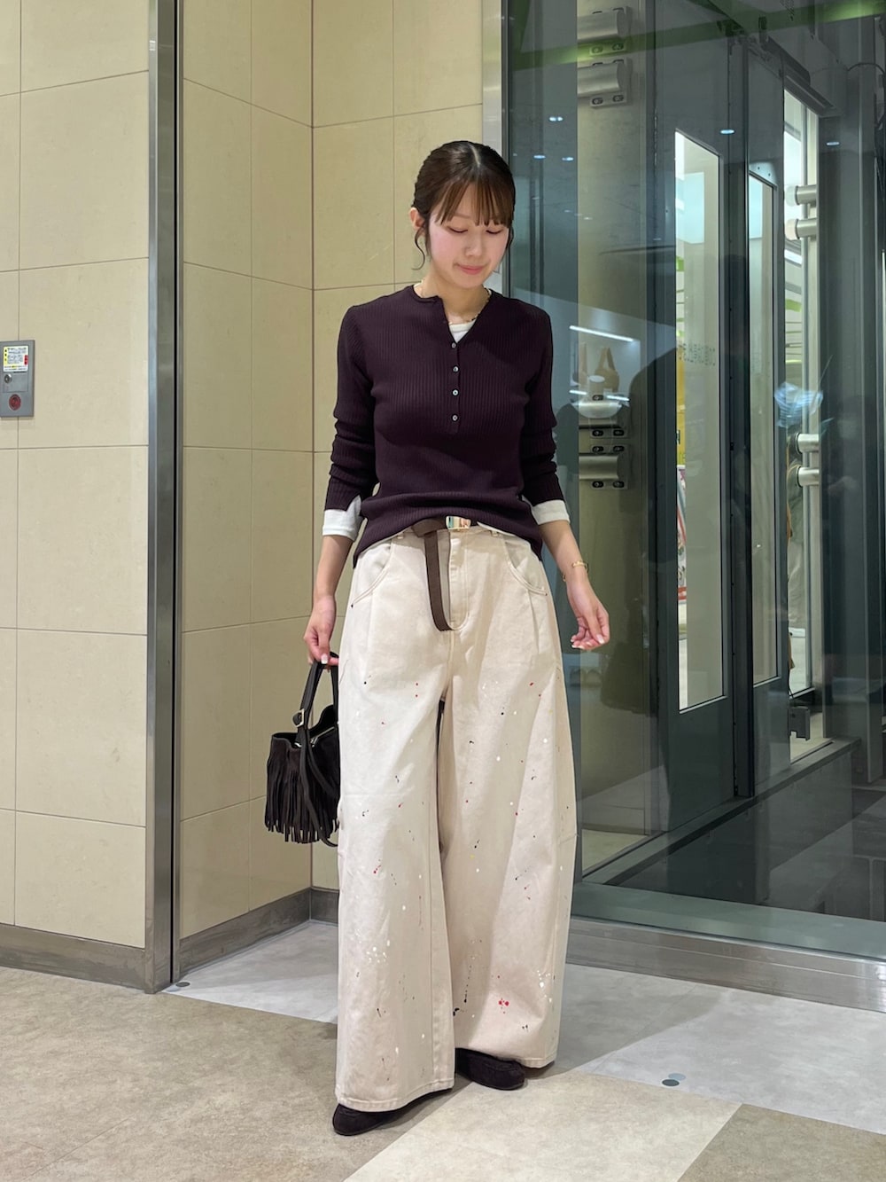 ベージュ系のその他パンツ、ホワイト系のTシャツ/カットソー、ブラウン系のニット/セーターを着用したレディースの秋コーディネートの4枚目の写真