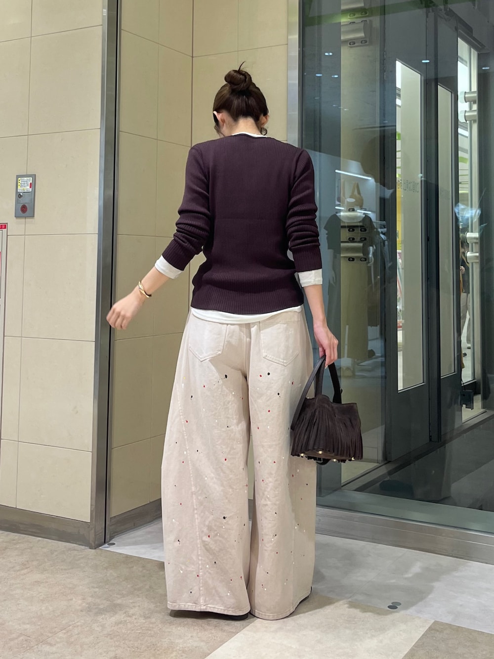 ベージュ系のその他パンツ、ホワイト系のTシャツ/カットソー、ブラウン系のニット/セーターを着用したレディースの秋コーディネートの3枚目の写真