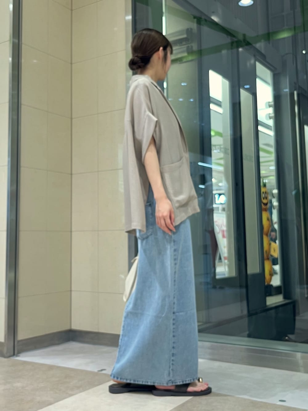 ブルー系のワンピース、ホワイト系のハンドバッグ、ブラック系のサンダルを着用したレディースの夏コーディネートの3枚目の写真