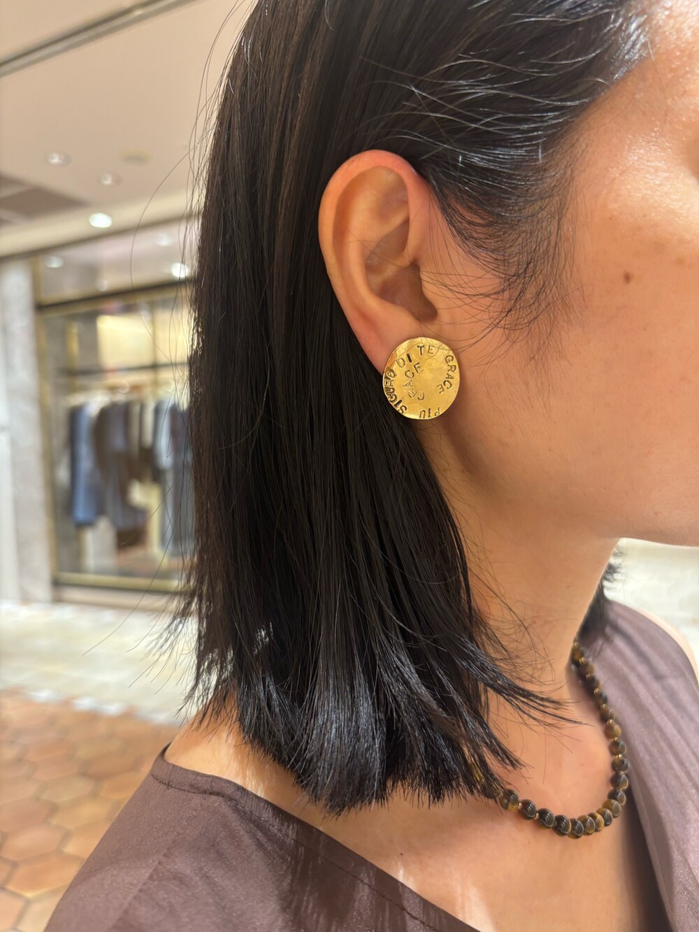 ブラウン系のワンピース、ブラウン系のバッグ、ブルー系のデニムジャケットを着用したレディースの夏コーディネートの4枚目の写真