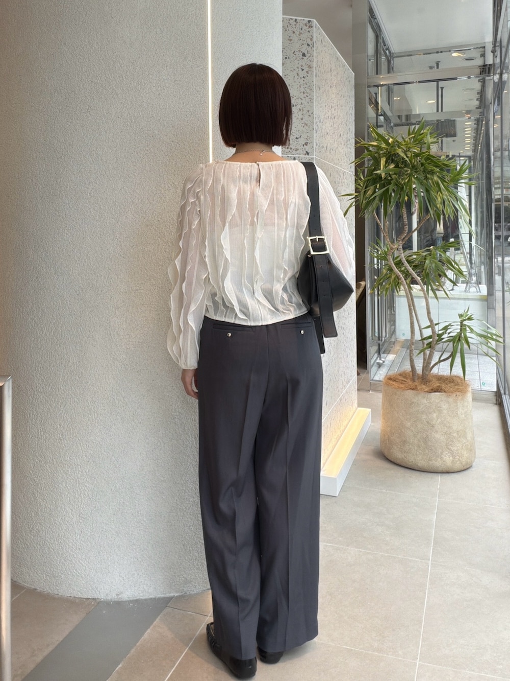 ホワイト系のTシャツ/カットソー、グレー系のその他パンツ、ブラック系のショルダーバッグを着用したレディースの秋コーディネートの3枚目の写真